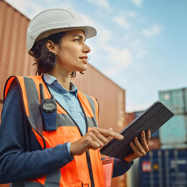 woman wearing a hard hat in a shipping container warehouse